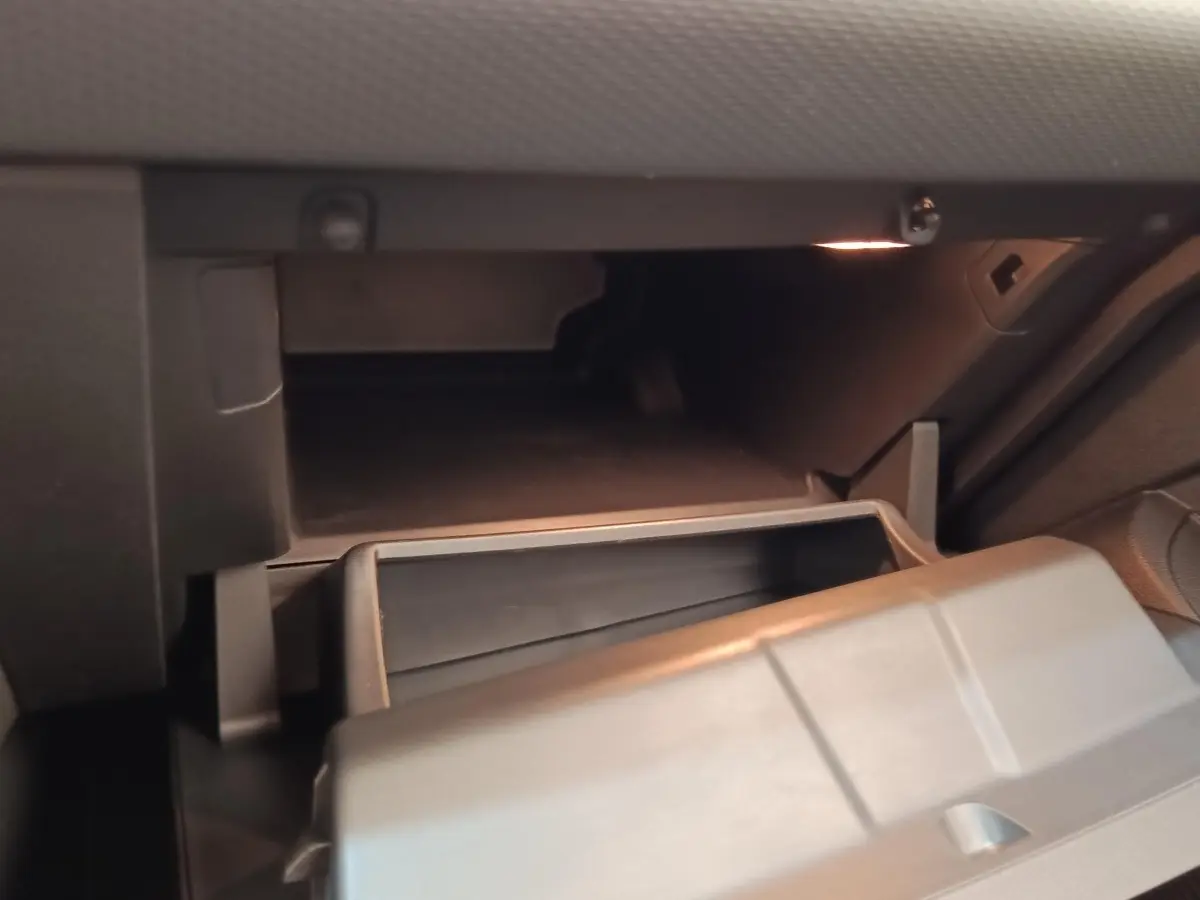 Gros plan sur la boîte à gants ouverte de la Renault Clio Business TCe 100 2021, intérieur gris sombre.