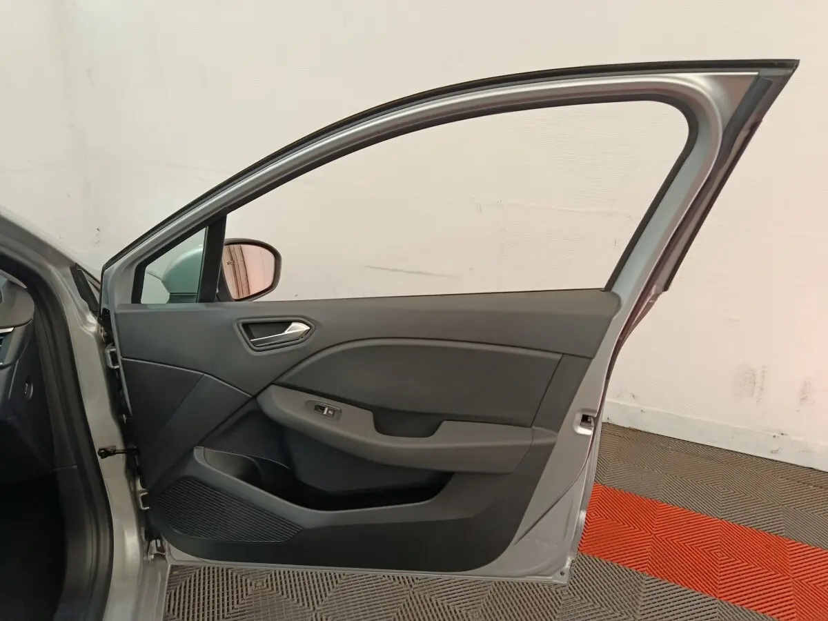 Vue intérieure de la porte avant gauche gris clair de la Renault Clio Business TCe 100, avec poignée et commande de vitre.