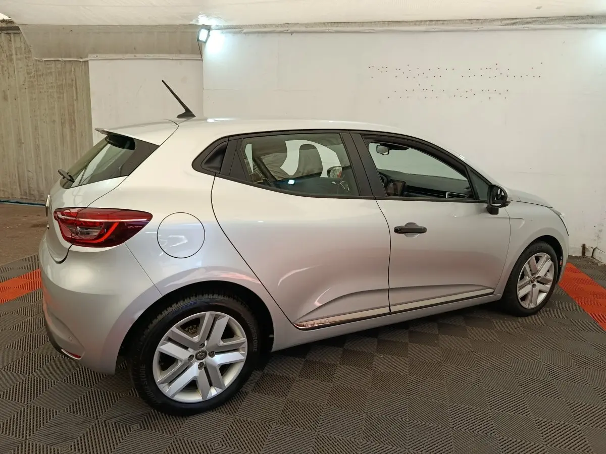 Renault Clio Business TCe 100 gris clair vue de profil côté droit, avec jantes alliage et antenne sur le toit.
