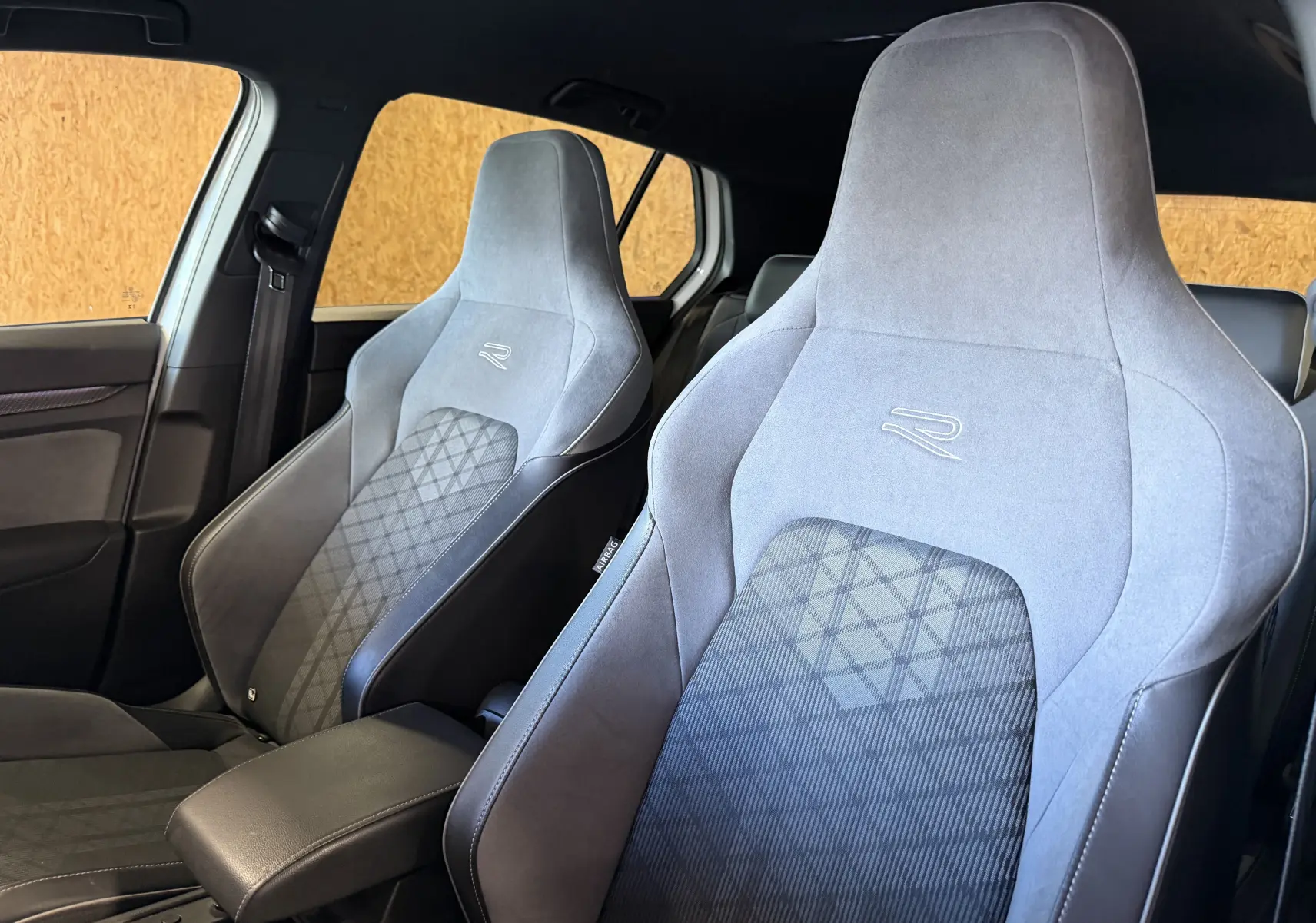 Vue intérieure rapprochée des sièges avant gris et noirs avec logo R de la Volkswagen Golf 2.0 TDI 150 DSG7 R-Line 2023.