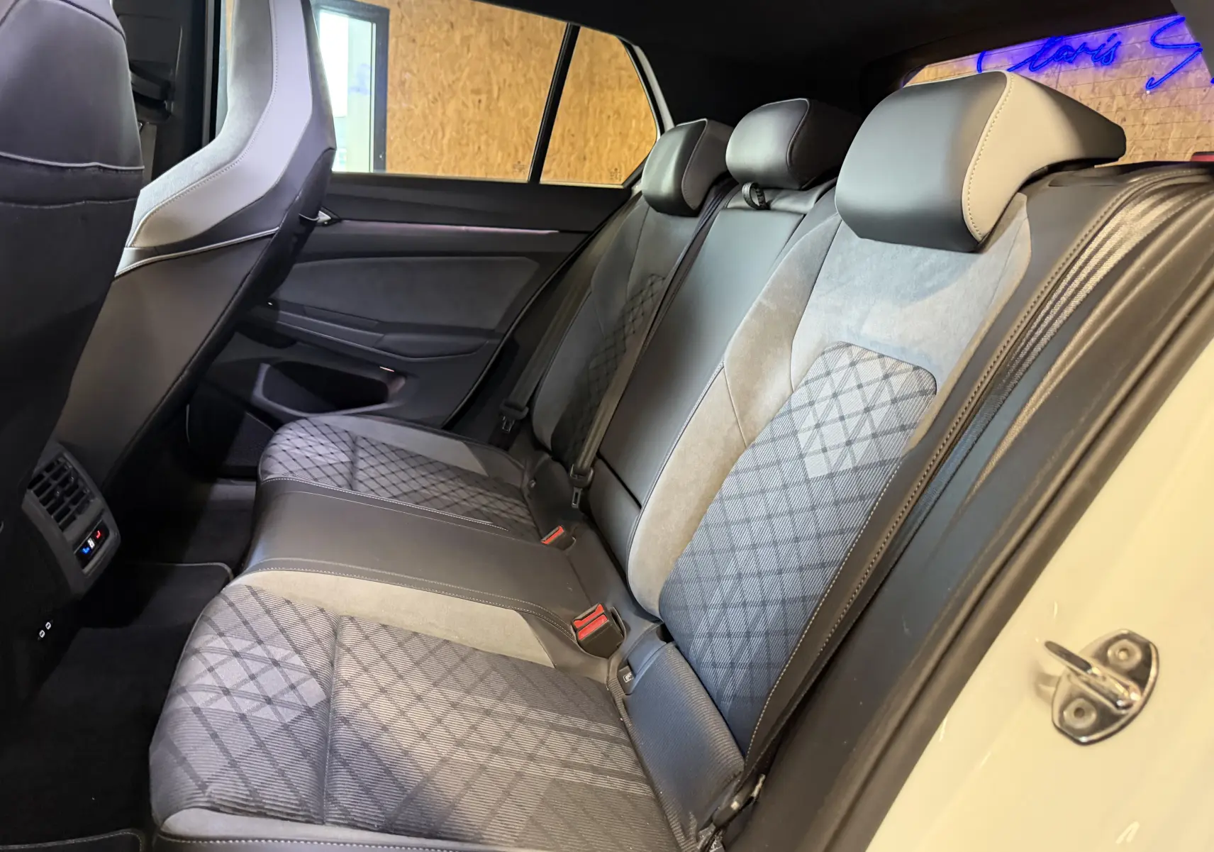 Vue intérieure côté droit des sièges arrière en tissu et cuir gris de la Volkswagen Golf 2.0 TDI 150 DSG7 R-Line blanche 2023.