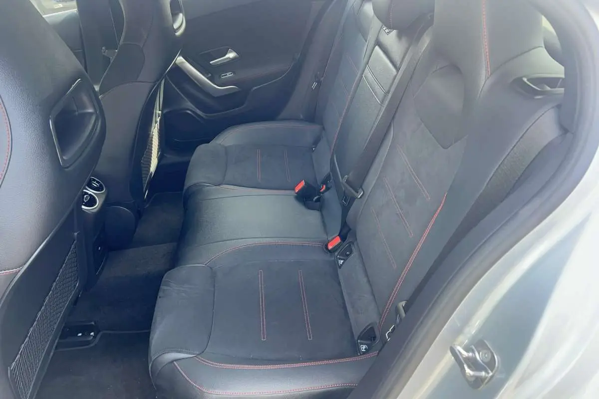 Vue intérieure côté droit de la banquette arrière en cuir tissu noir avec surpiqûres rouges d'une Mercedes Classe A AMG Line argent high-tech metal.