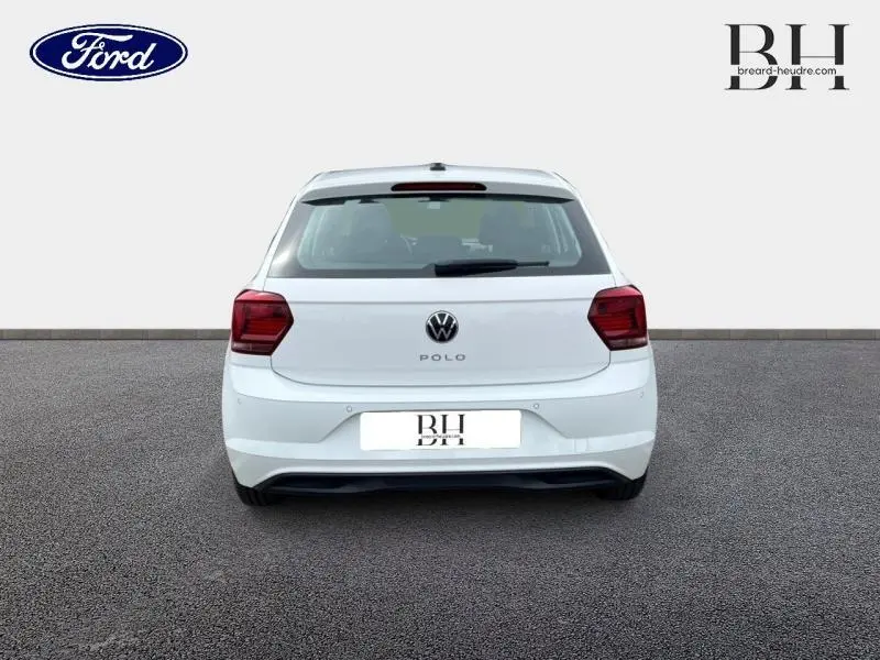 Vue arrière d'une Volkswagen Polo blanche Pure avec feux arrière rouges et logo VW bien visible.