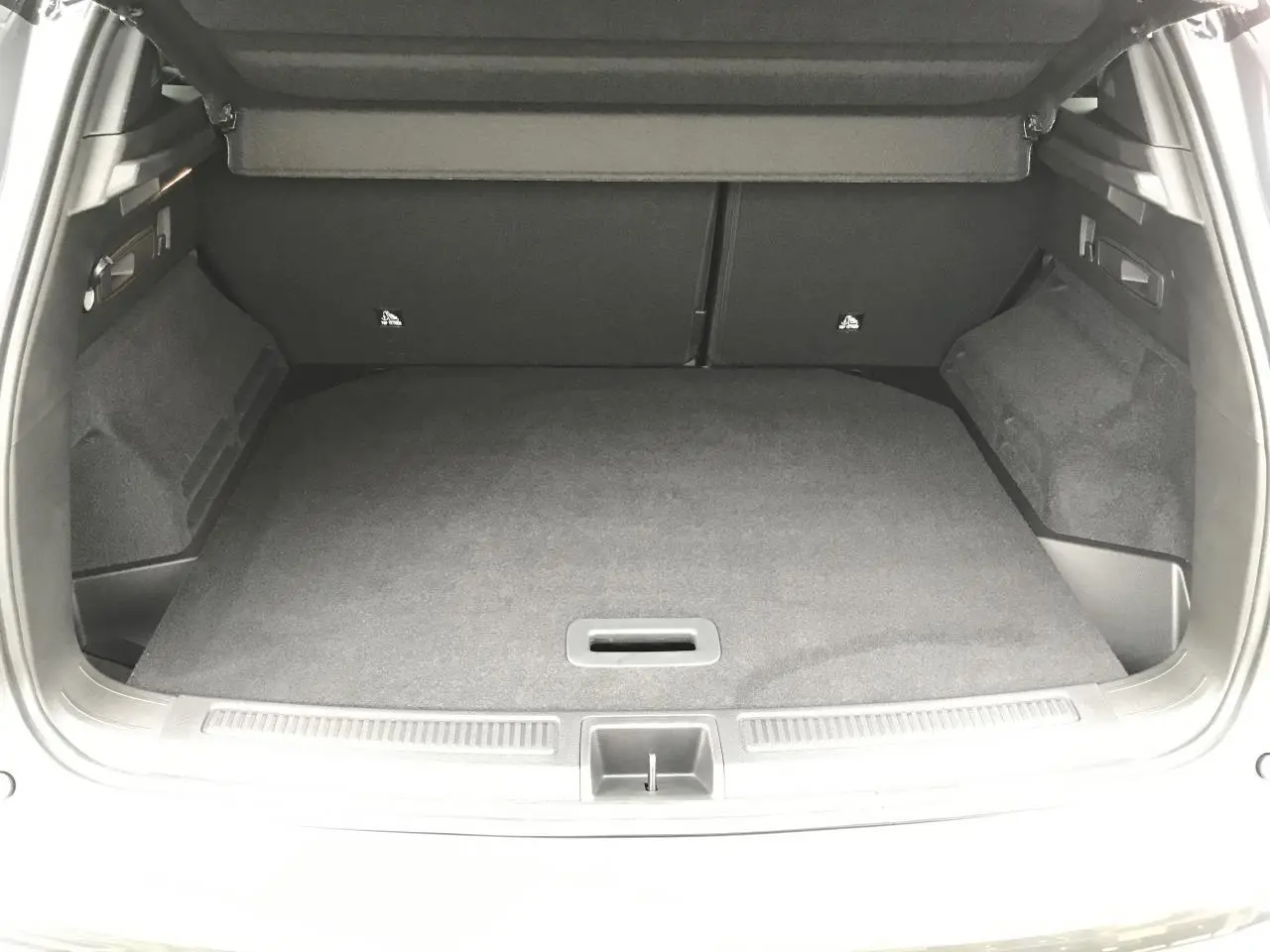 Coffre ouvert vu de l'arrière du Renault Austral gris bi-ton, montrant le faux plancher et l'espace de chargement.