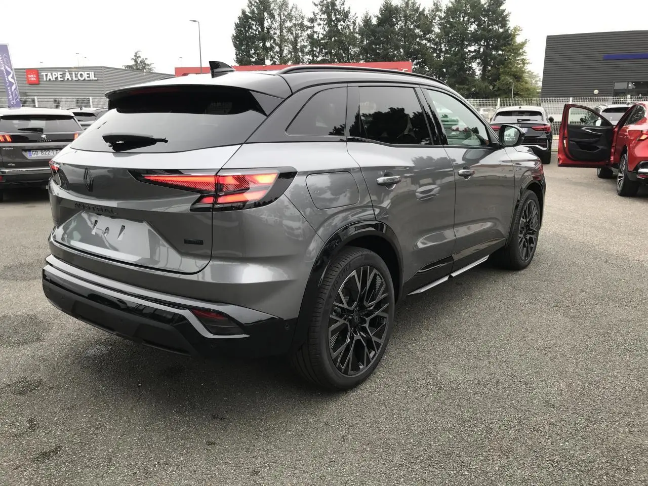 Vue 3/4 arrière droit d'un Renault Austral gris métallisé bi-ton noir avec jantes alliage noires et feux arrière LED 3D.