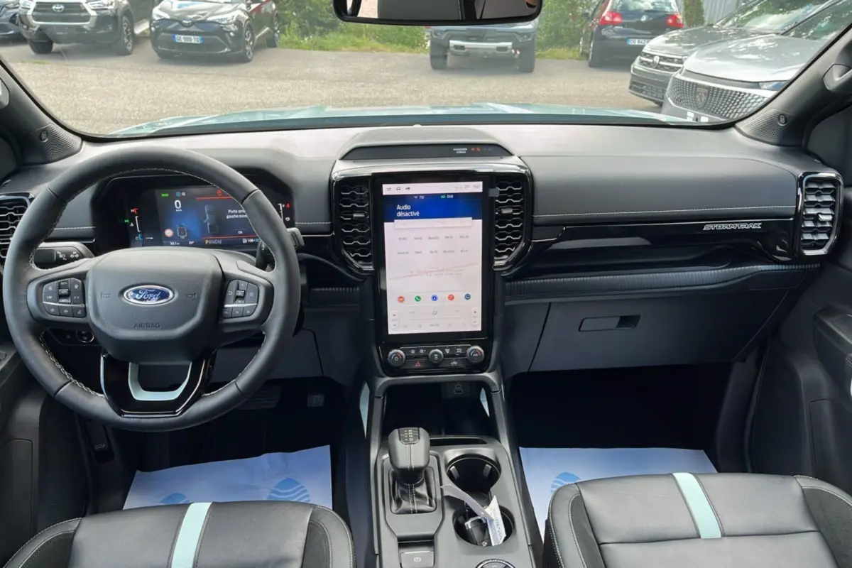 Vue intérieure avant du Ford Ranger gris zen 2026, tableau de bord avec écran tactile vertical et volant multifonctions.