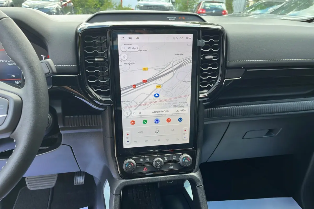 Vue intérieure centrée sur l'écran tactile vertical du Ford Ranger gris zen avec volant multifonctions partiel visible à gauche.