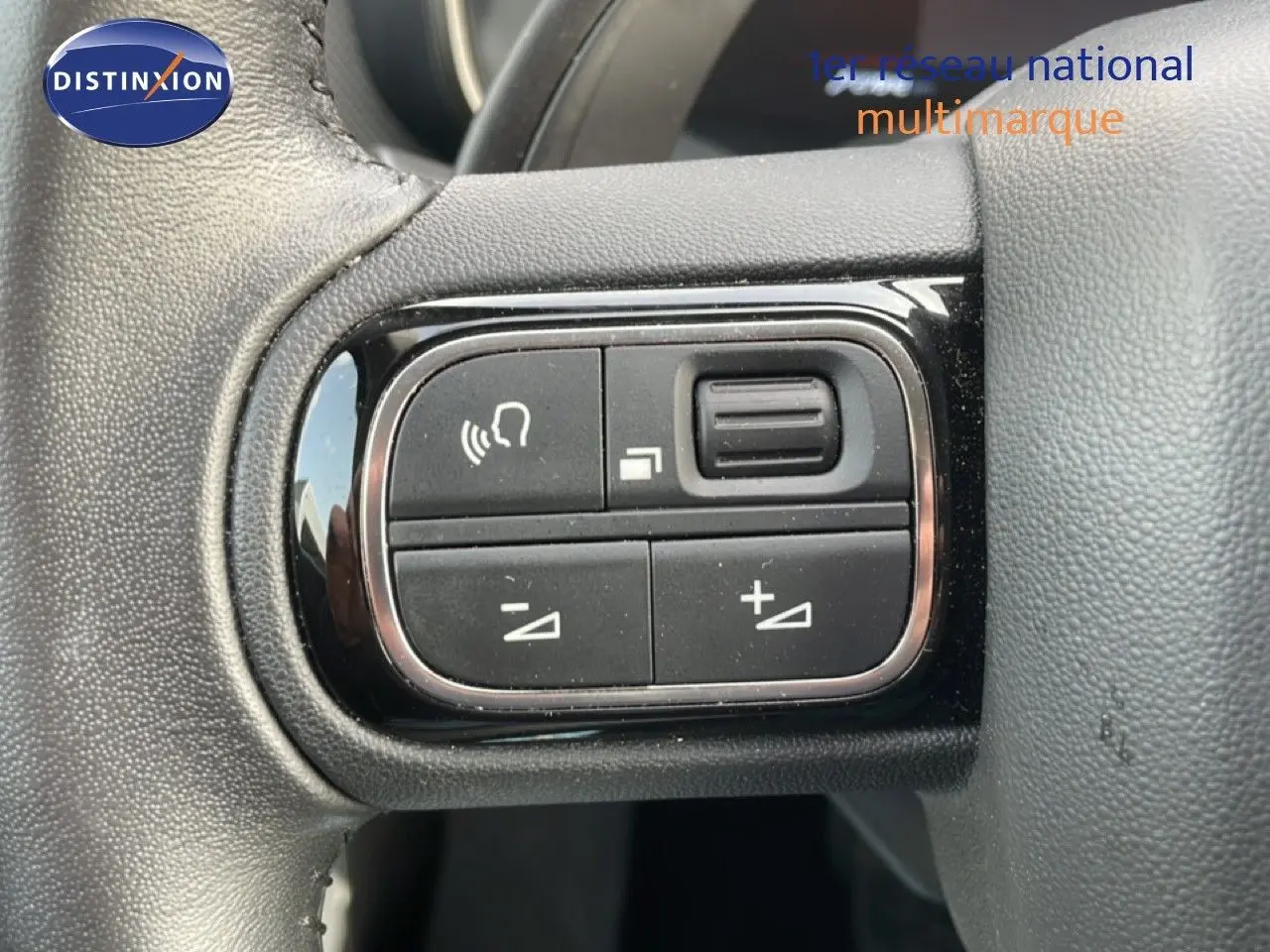 Gros plan sur les commandes noires du volant du Citroën C5 Aircross 2024, finition Bleu Eclipse Metal.