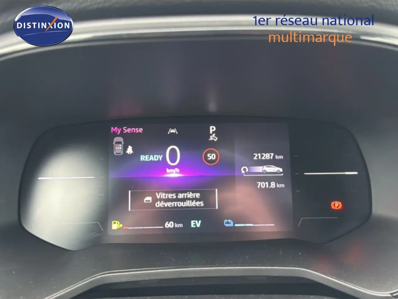 Tableau de bord numérique de Renault Clio hybride 2025 affichant vitesse, autonomie et alertes, vue frontale rapprochée.