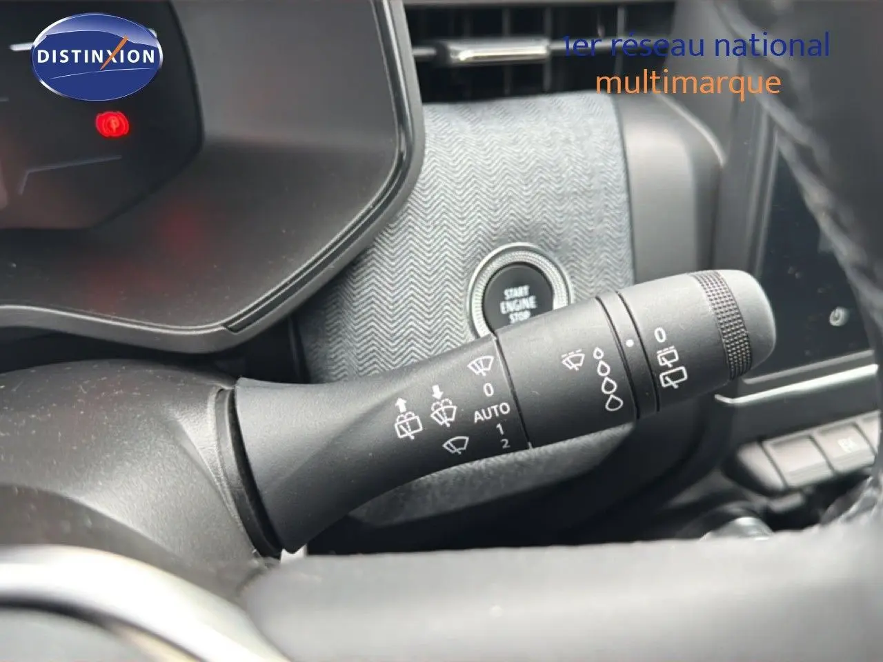 Gros plan sur la commande d'essuie-glace à gauche du volant dans l'habitacle gris noir de la Renault Clio 2025.