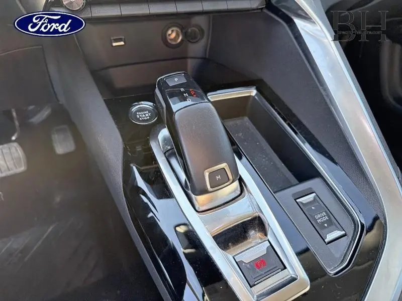 Gros plan sur la console centrale avec levier de boîte automatique noir et boutons de contrôle dans un Peugeot 5008 gris Platinium.