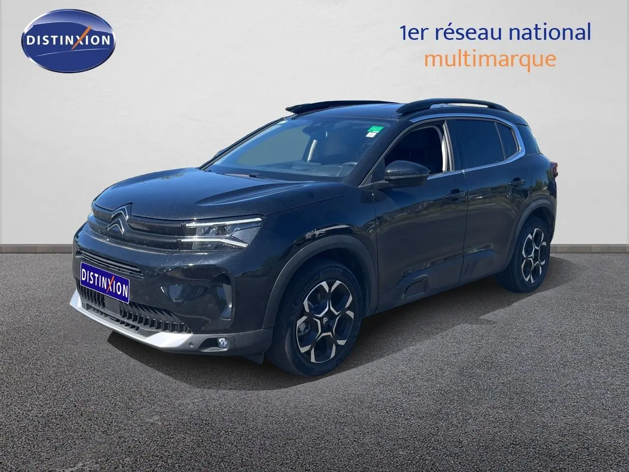 Citroën C5 Aircross noir métal en 3/4 avant droit, avec jantes distinctives et toit ouvrant visible.