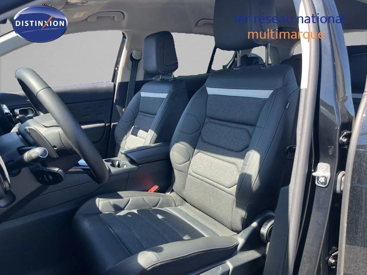 Vue intérieure côté conducteur du Citroën C5 Aircross noir métal 2025, sièges avant en tissu et cuir noir.