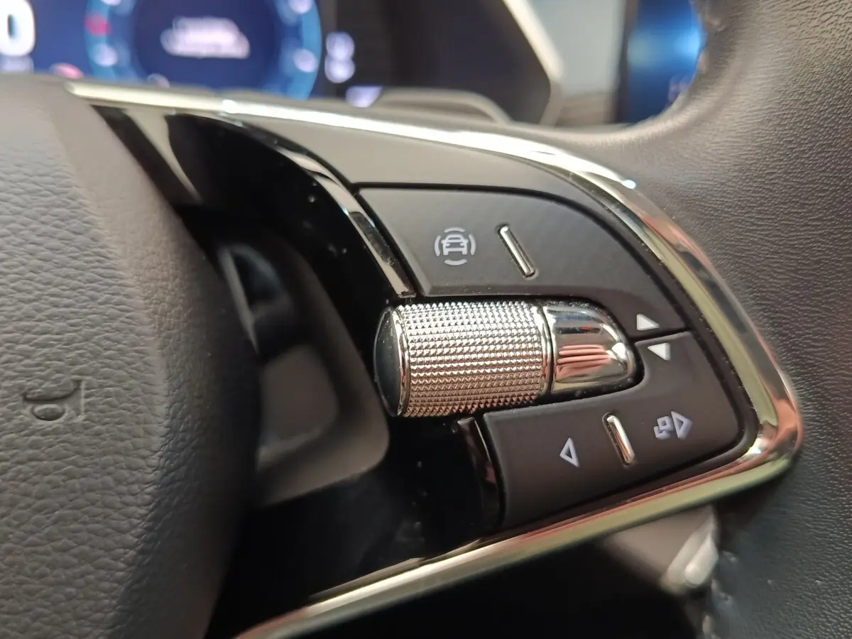 Gros plan sur la molette de commande multifonctions en aluminium du volant cuir noir de la Skoda Octavia 2023.