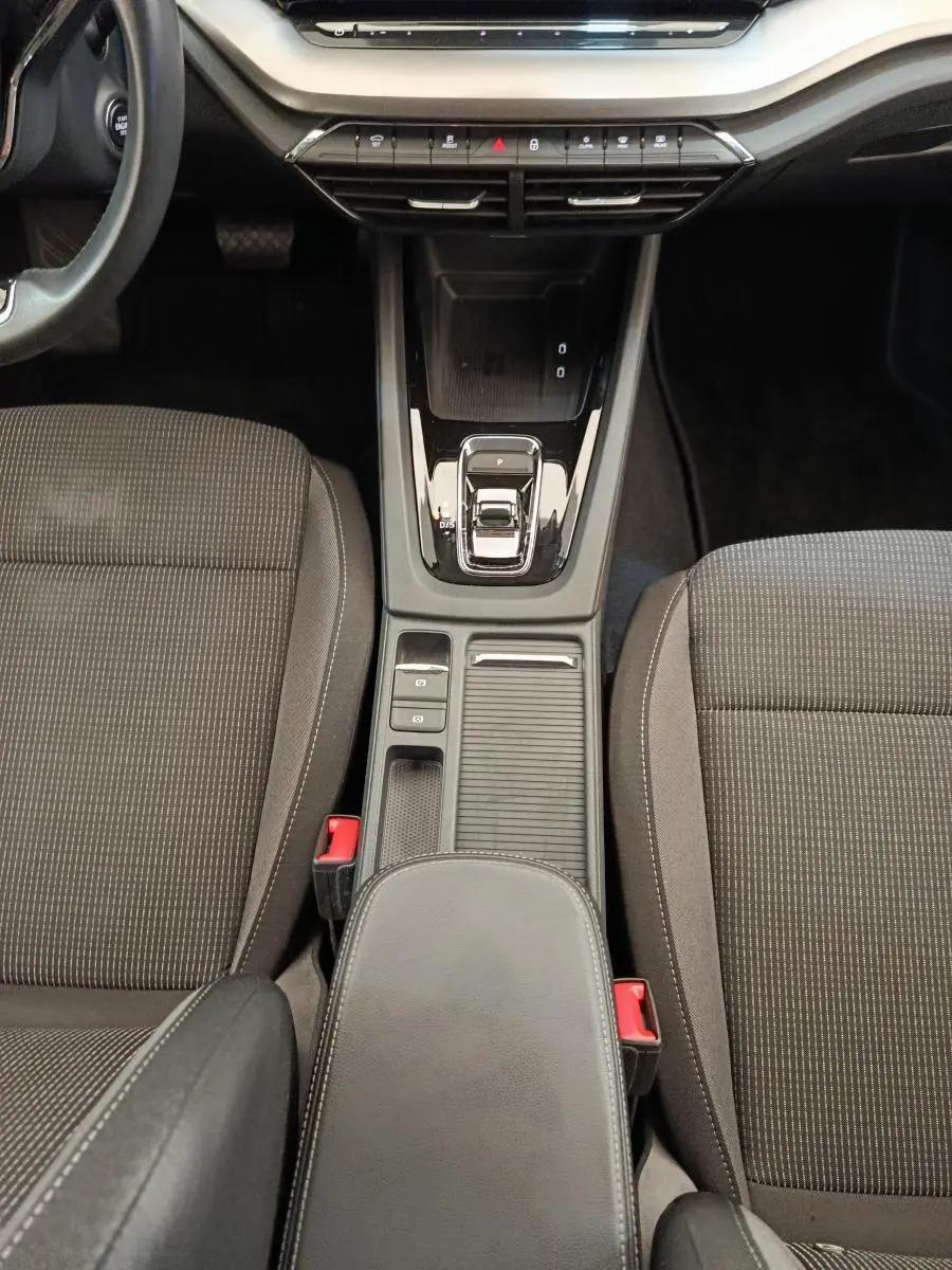 Vue plongeante sur la console centrale noire et les sièges tissu gris de la Skoda Octavia 2.0 TDI 150 DSG7 Ambition.