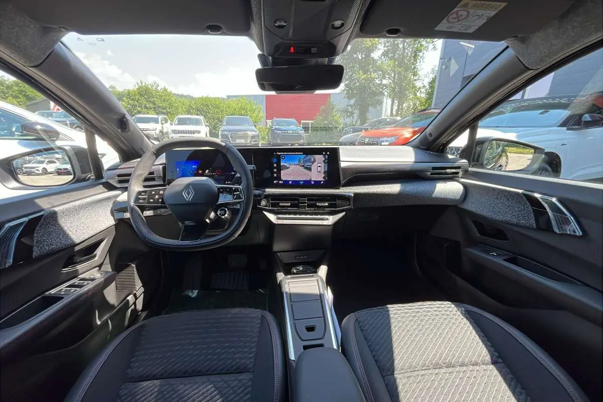 Vue intérieure avant de la Renault Clio 6 TCE 115 EDC Techno Plus, tableau de bord moderne avec écran tactile et volant multifonctions.