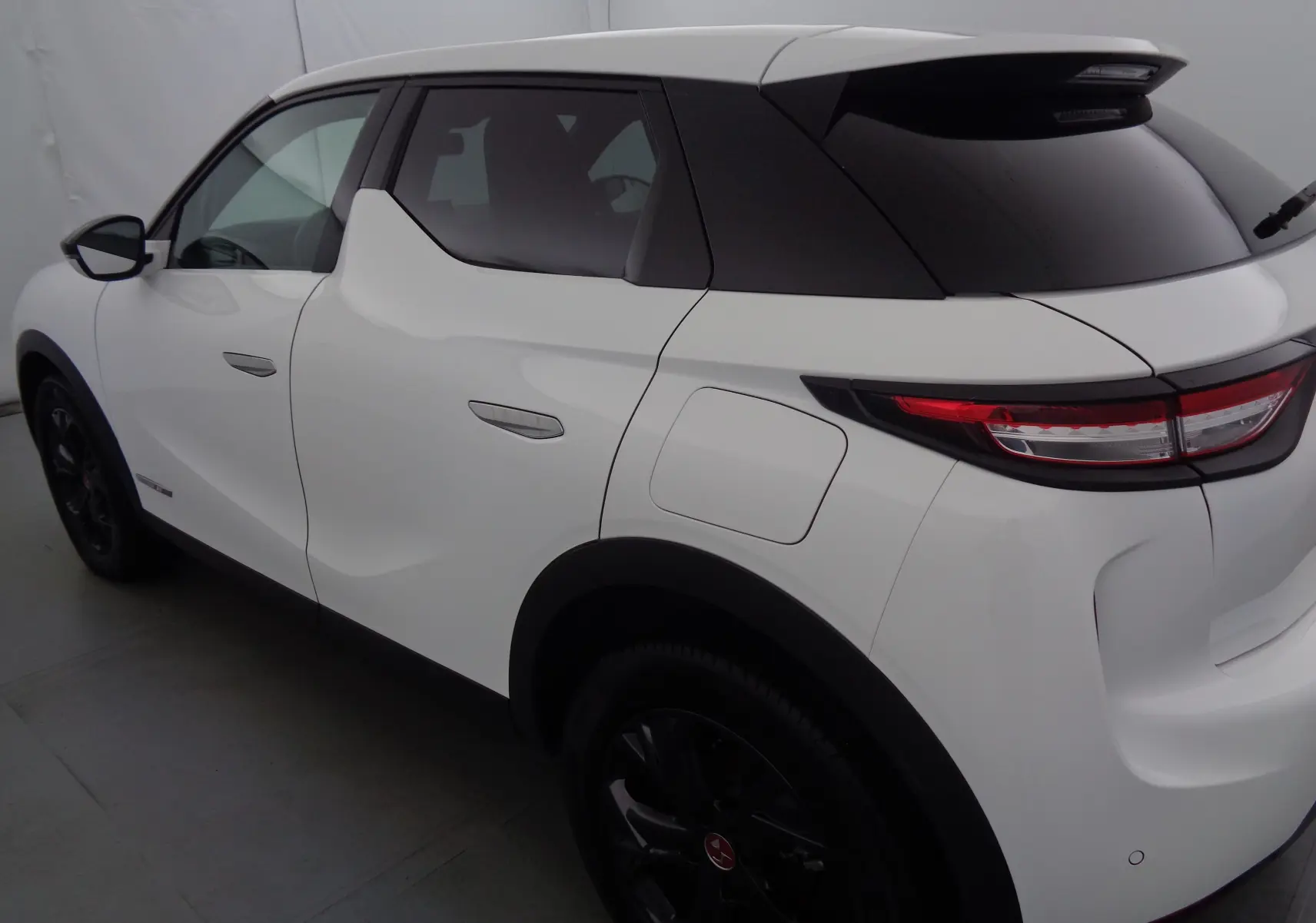 Vue 3/4 arrière droite du DS3 Crossback blanc banquise avec toit noir et jantes noires distinctives