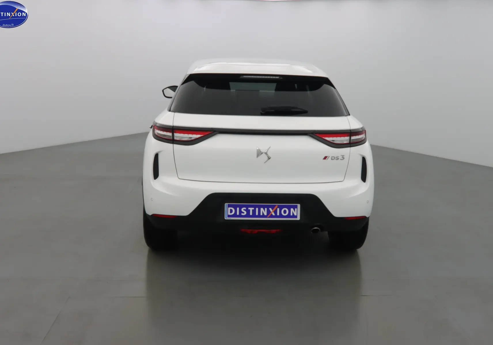 Vue arrière d'une DS3 Crossback blanche Banquise avec feux LED étirés et logo DS centré sur le hayon.