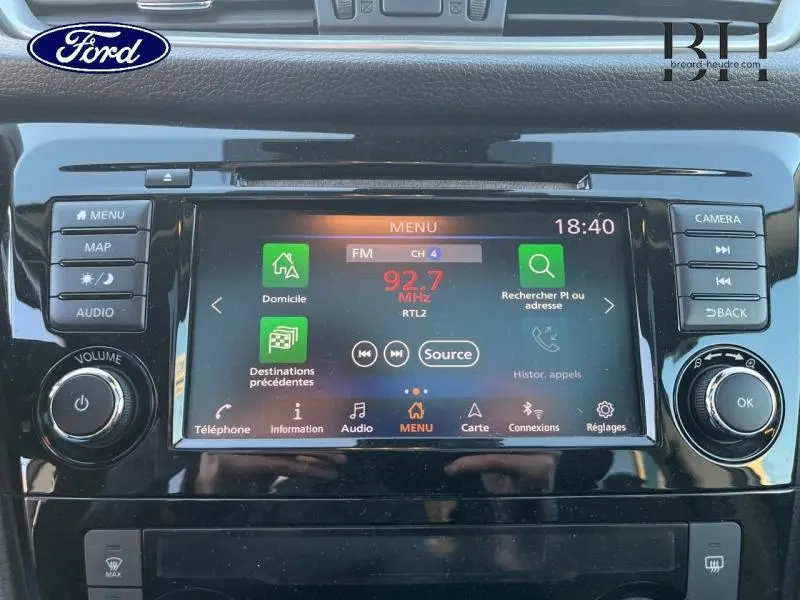 Écran tactile central du Nissan Qashqai 2019 gris Squale affichant la radio FM et les options de navigation.