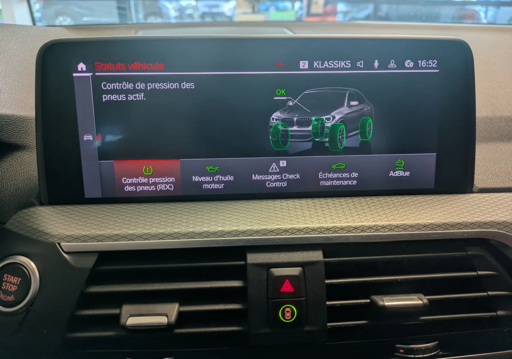 Écran central du tableau de bord BMW X4 blanc 2021 affichant le contrôle actif de la pression des pneus.