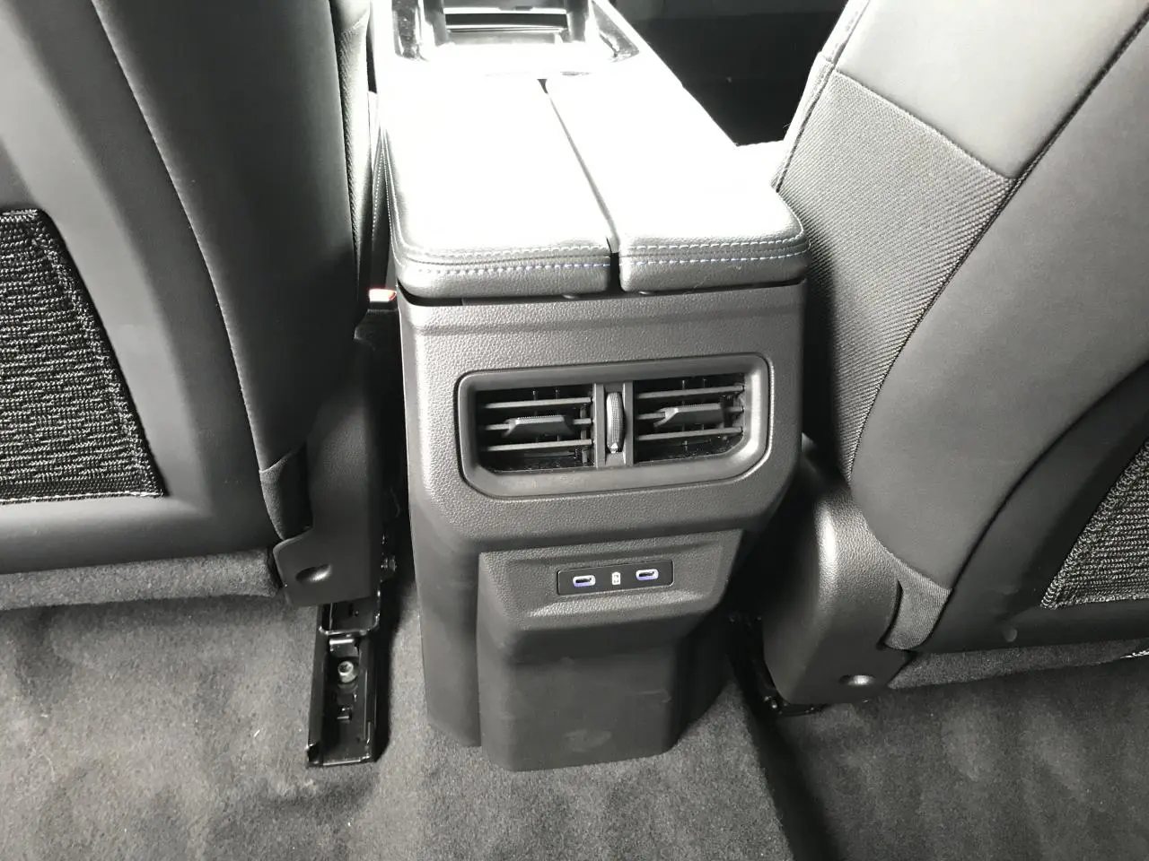Vue rapprochée de la console arrière avec bouches d’aération et ports USB du Renault Austral blanc.