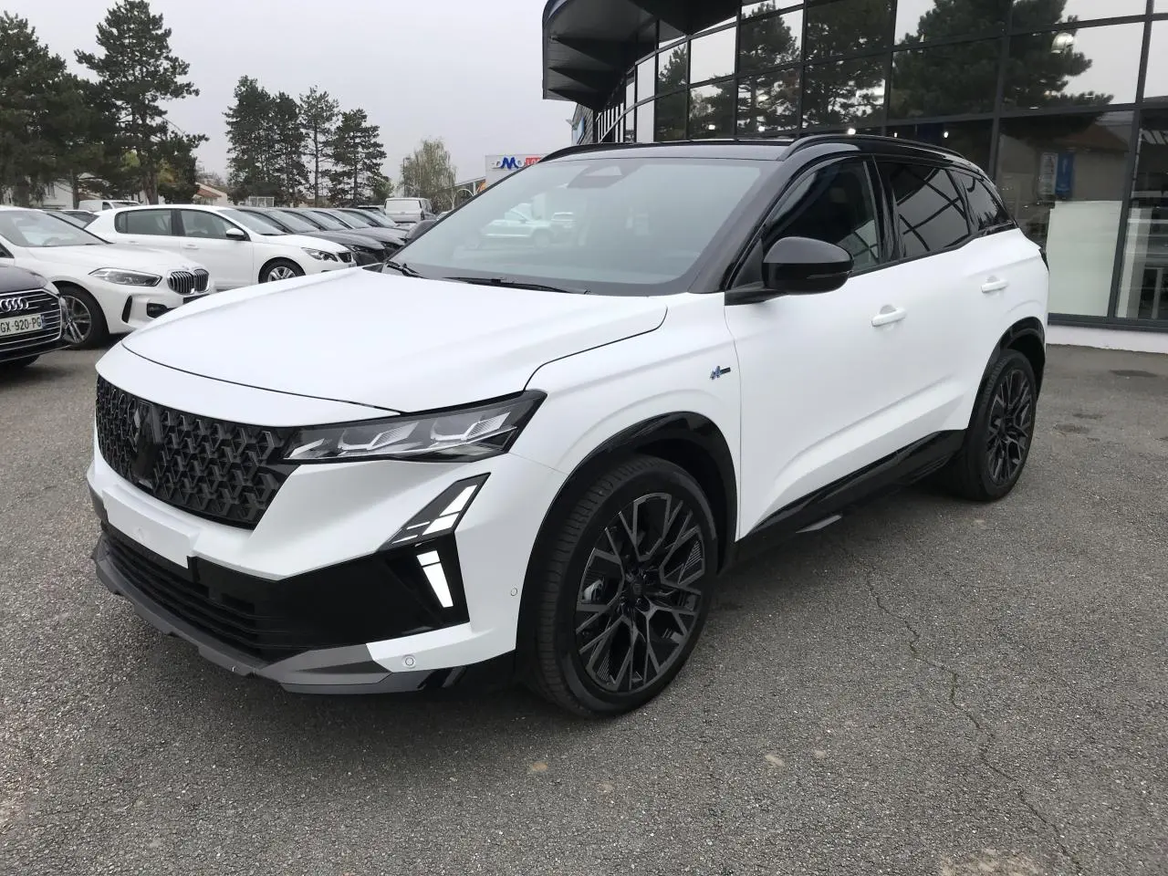 Renault Austral blanc bi-ton vue 3/4 avant droit, jantes noires et toit noir satin distinctifs.