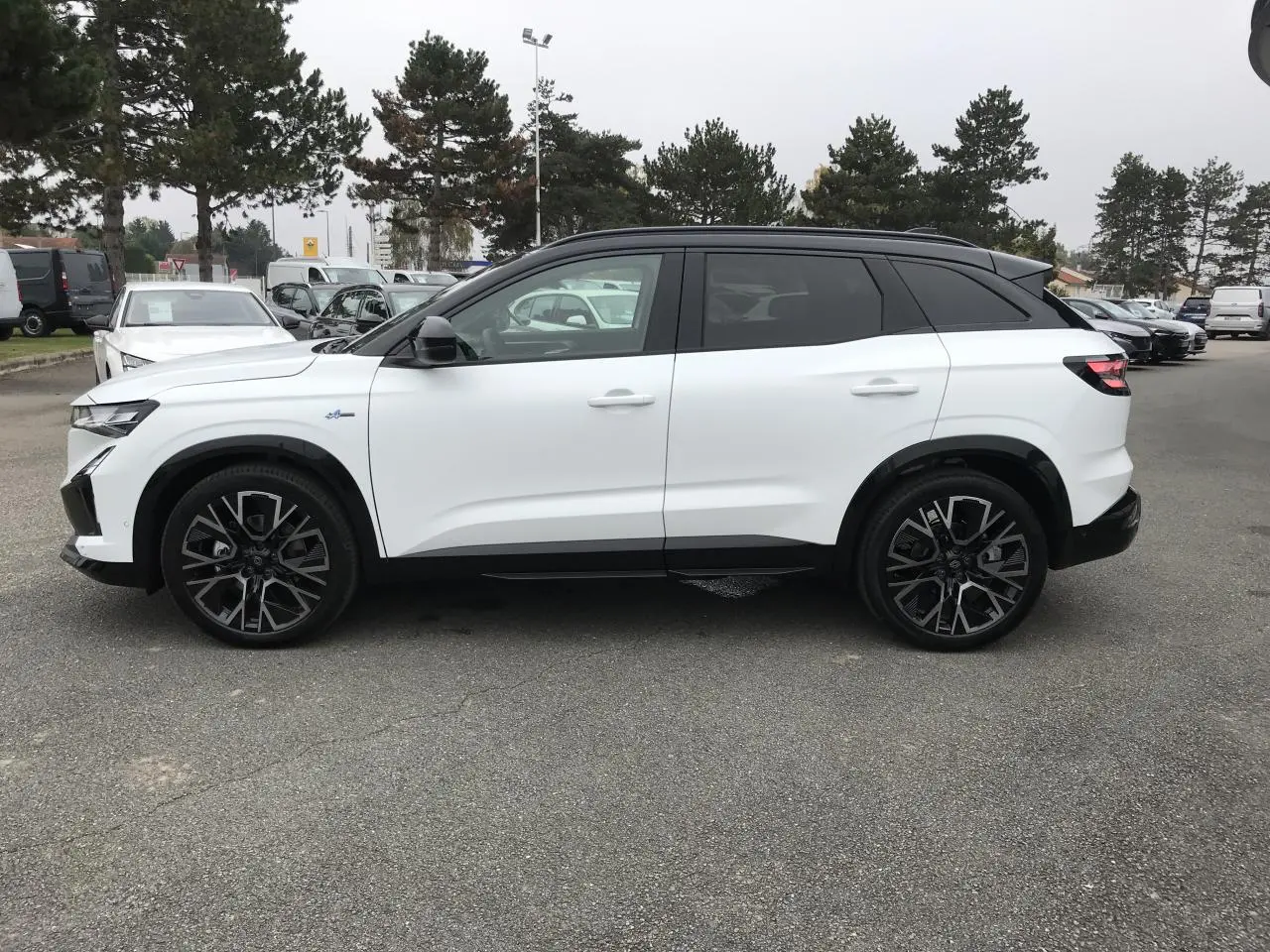 Renault Austral blanc bi-ton vue de profil côté gauche avec jantes alliage noires et toit noir satin.