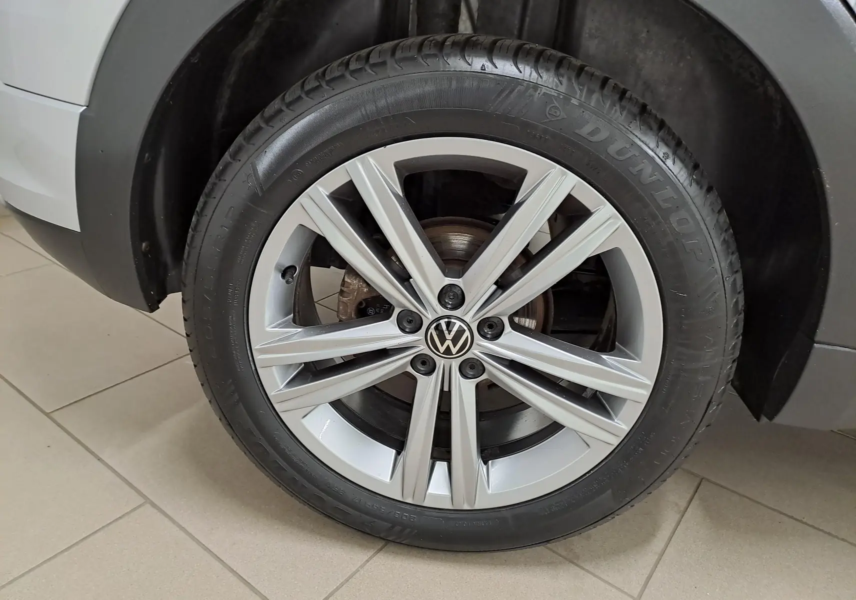 Gros plan sur la roue avant droite du Volkswagen T-Cross 2022 R-Line en reflet d'argent avec jante alliage distinctive.