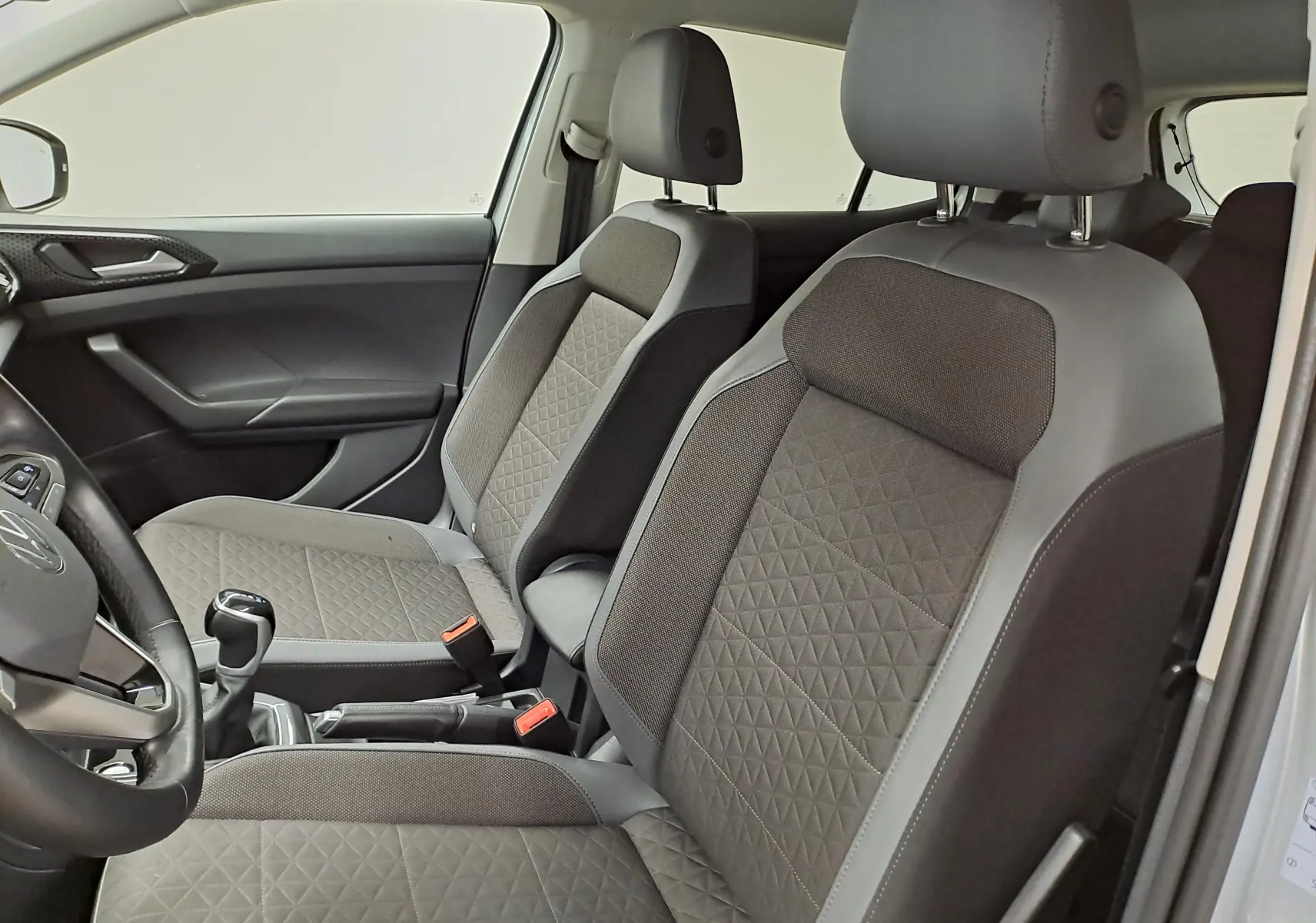 Vue intérieure côté conducteur du Volkswagen T-Cross 2022 en finition R-Line, sièges gris avec surpiqûres en losange.