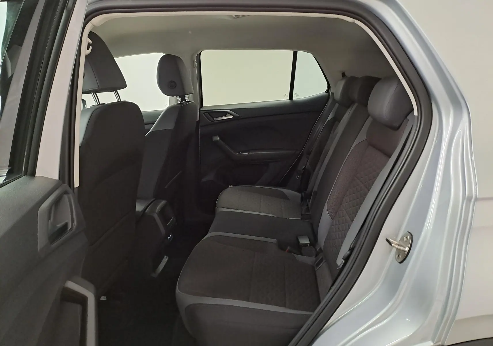 Vue intérieure côté arrière droit du Volkswagen T-Cross 2022 argent, montrant les sièges arrière en tissu noir avec surpiqûres.