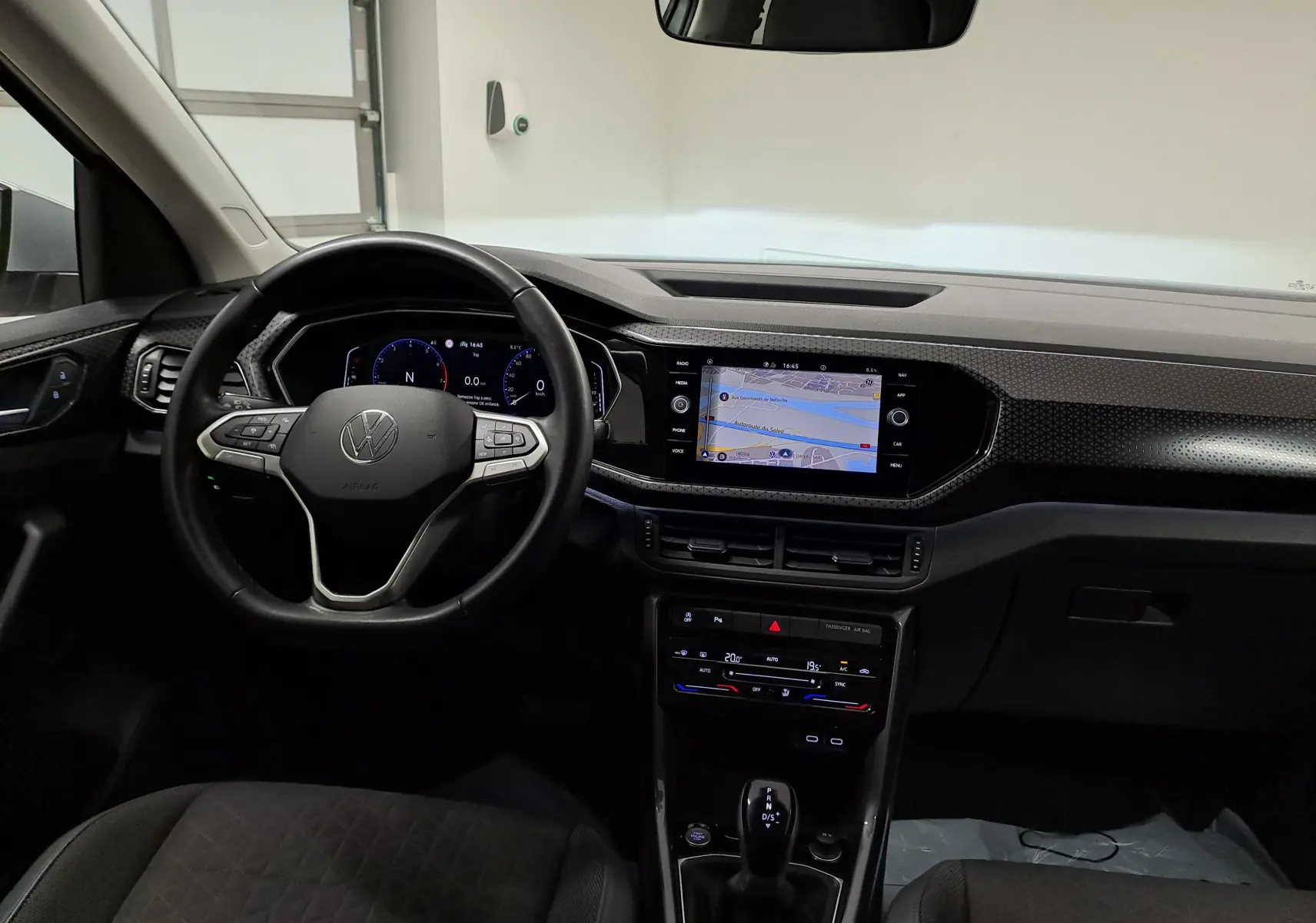 Vue intérieure avant du Volkswagen T-Cross 1.0 TSI 110 DSG7 R-Line 2022, tableau de bord avec écran tactile et volant multifonction noir.