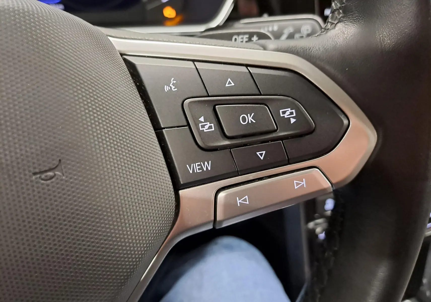 Gros plan sur les commandes multifonctions à droite du volant noir du Volkswagen T-Cross 2022 finition R-Line argentée.