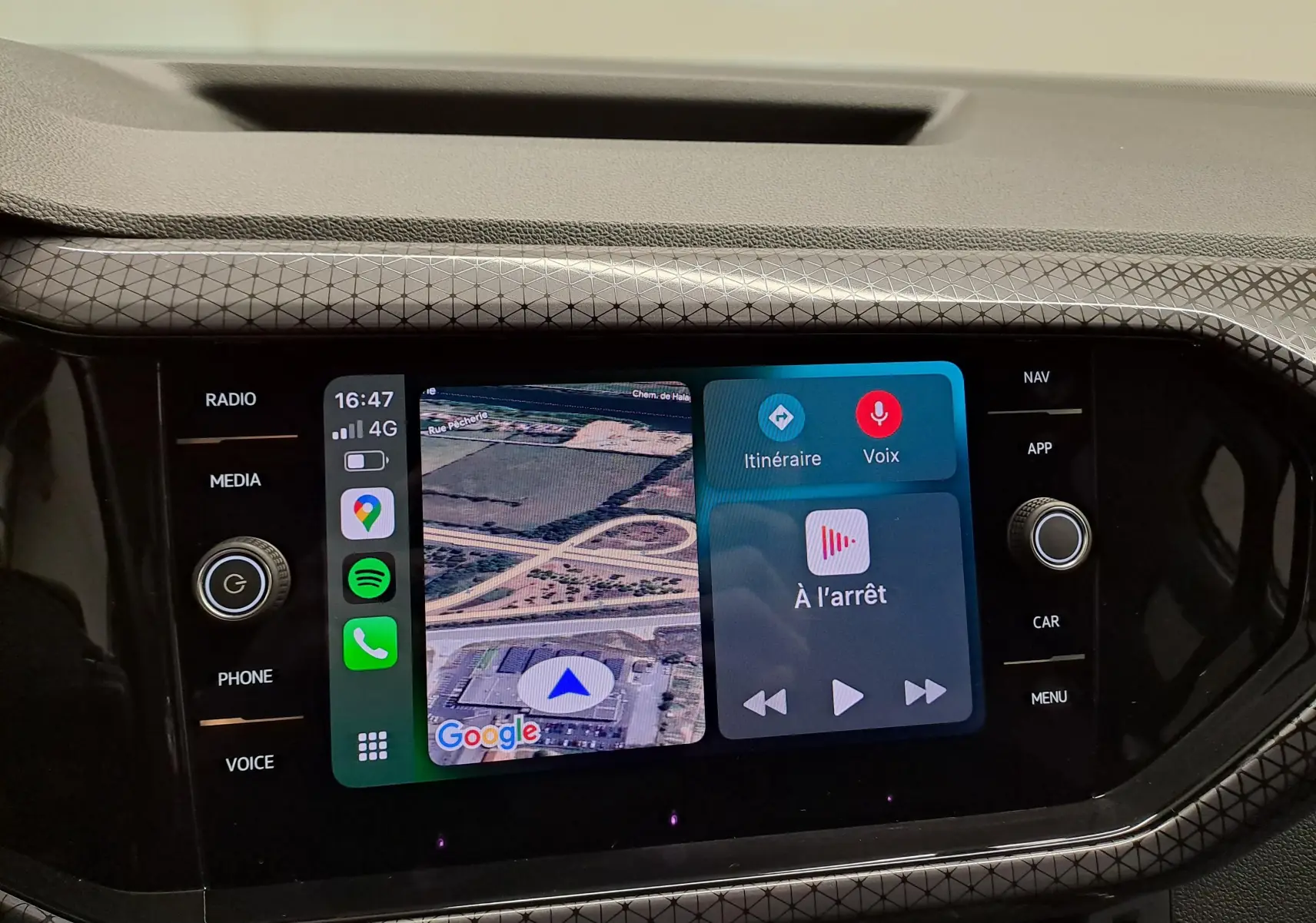 Écran tactile central du Volkswagen T-Cross 2022 affichant la navigation et les commandes multimédia, entouré d'un cadre noir texturé.
