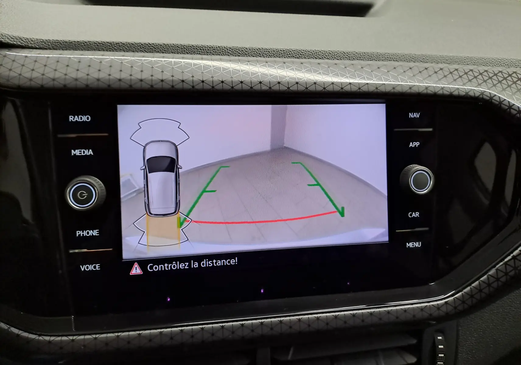 Affichage de la caméra de recul du Volkswagen T-Cross 2022 R-Line en reflet d'argent, vue arrière avec guidage de trajectoire.