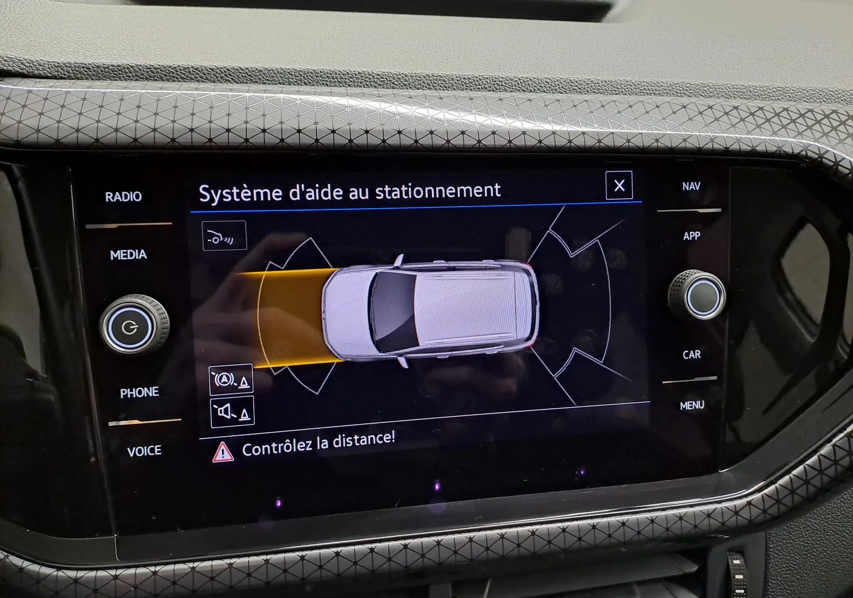 Écran central du Volkswagen T-Cross 2022 en reflet d'argent montrant le système d'aide au stationnement actif.