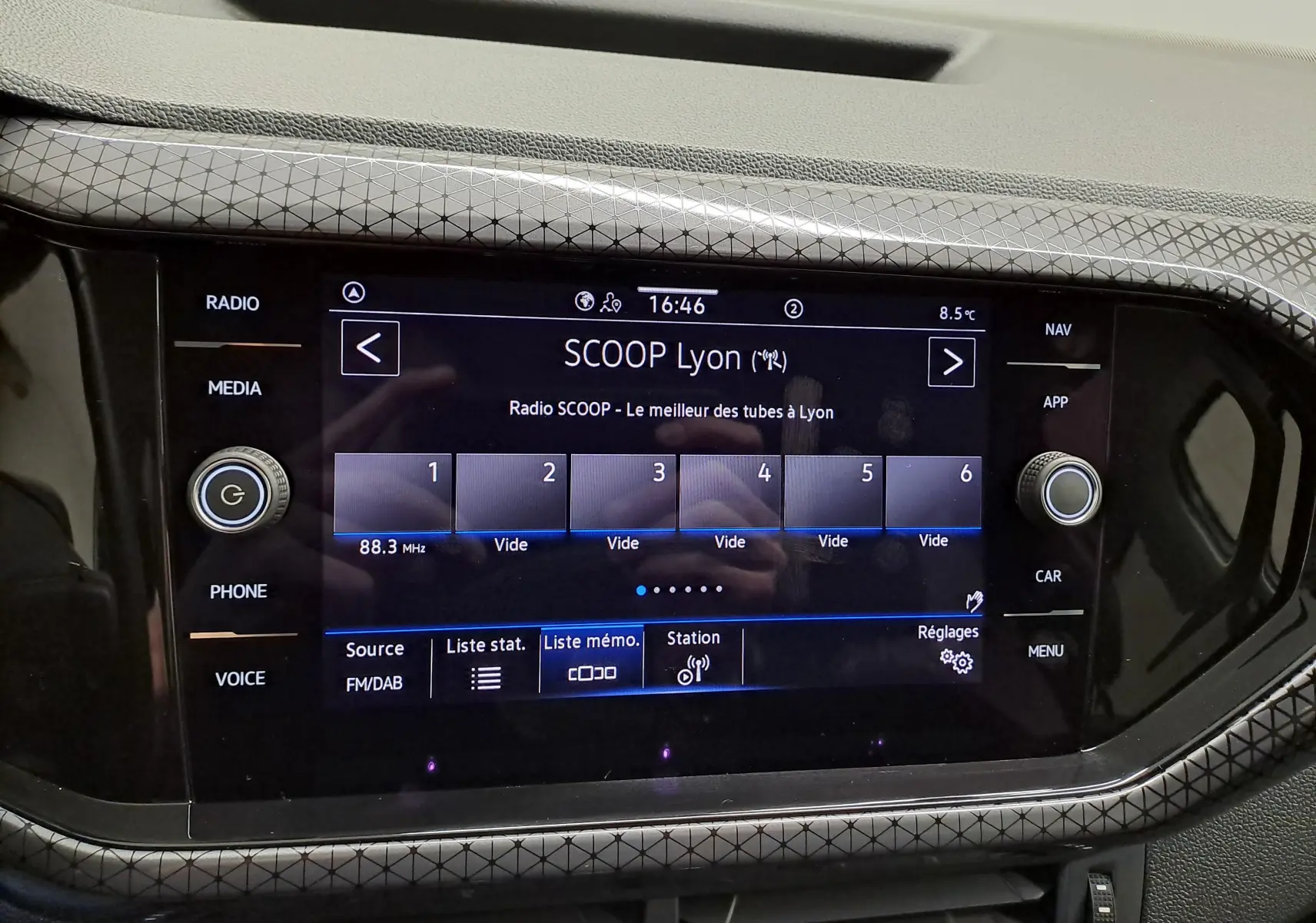 Écran tactile central du Volkswagen T-Cross 2022 R-Line, affichant la radio SCOOP Lyon avec cadre décoratif gris à motifs géométriques.