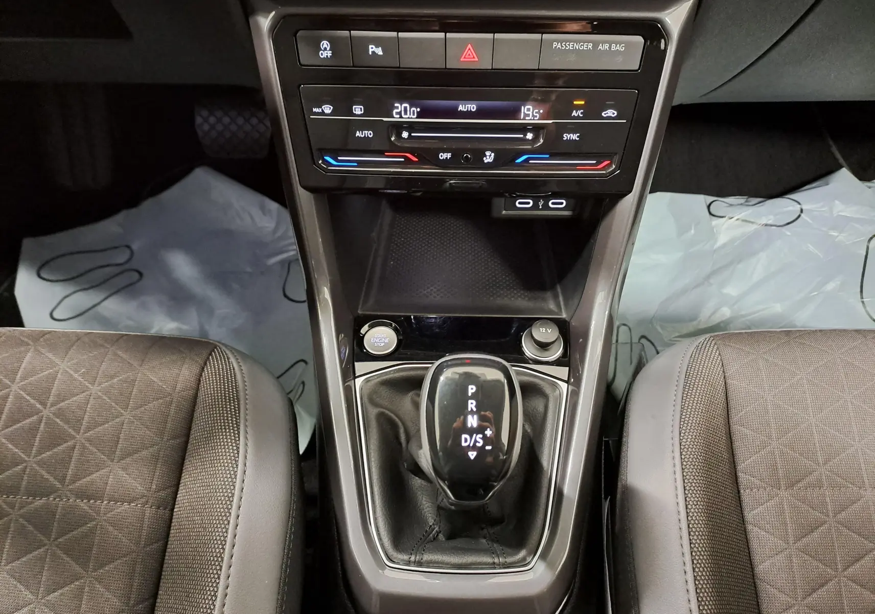 Vue rapprochée de la console centrale du Volkswagen T-Cross 1.0 TSI 110 DSG7 R-Line 2022 en reflet d'argent, avec levier de boîte auto.
