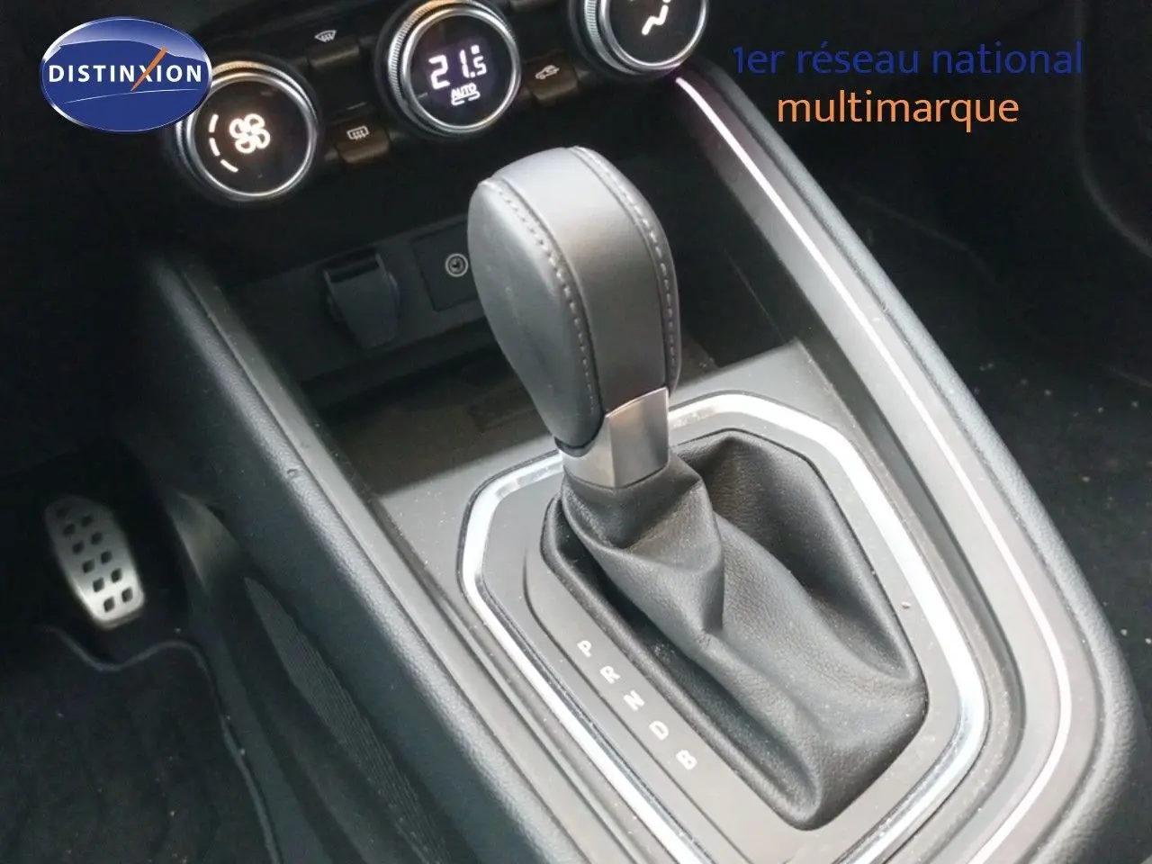 Gros plan sur la commande de boîte automatique de la Renault Clio 1.6 E-TECH 145ch, intérieur noir avec commandes de climatisation.