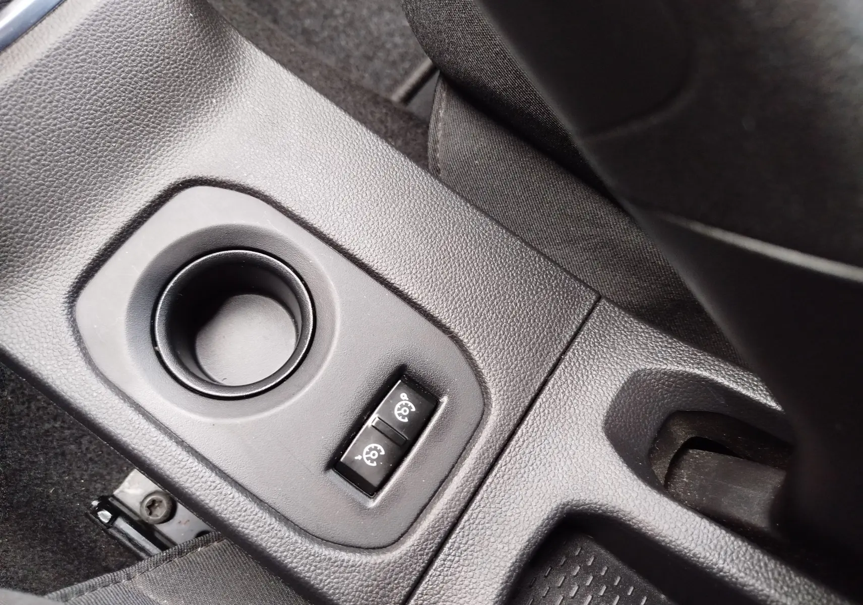 Gros plan sur la console centrale noire du Dacia Duster 2020, montrant deux boutons de réglage des rétroviseurs.