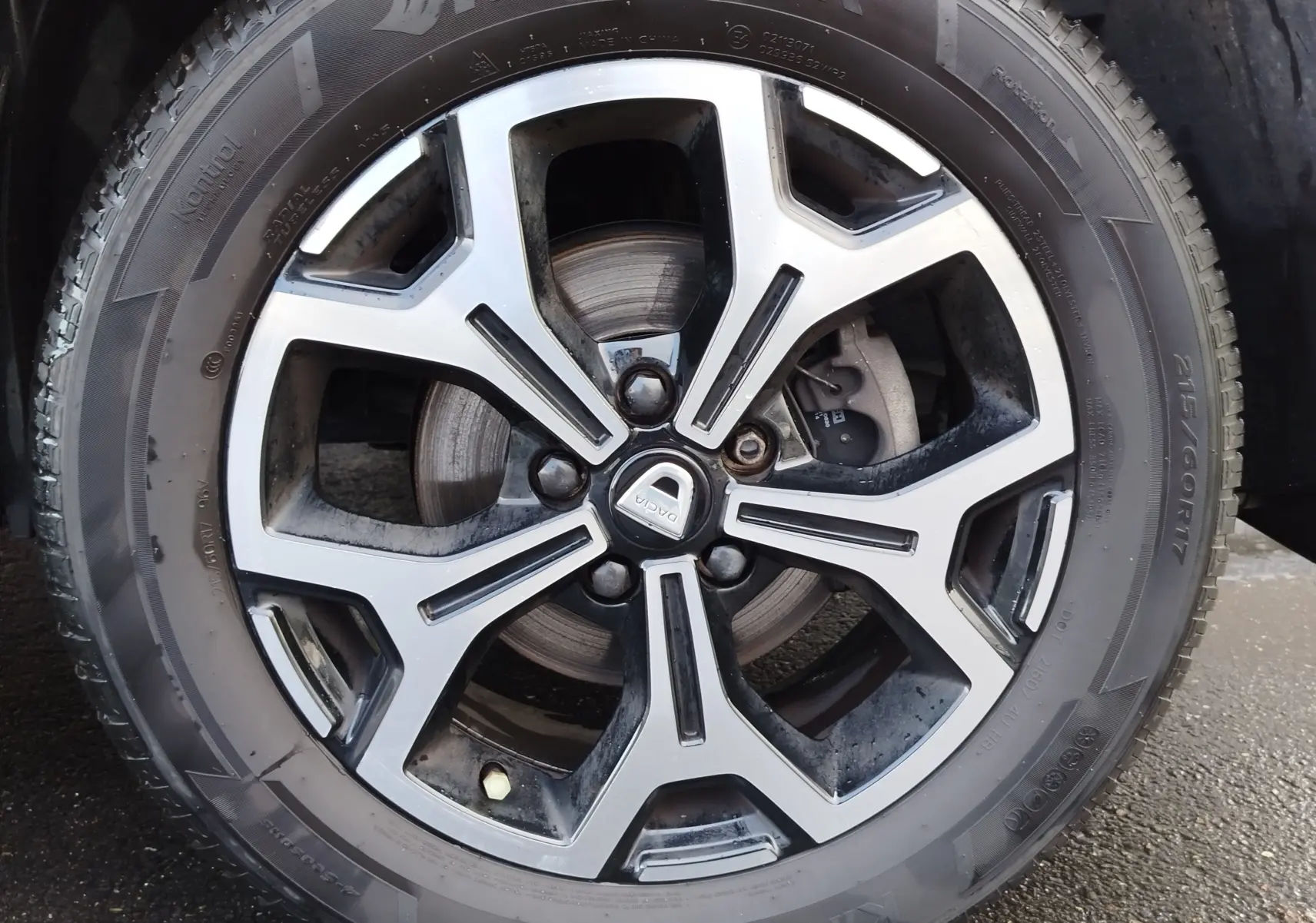 Gros plan sur la jante alliage bi-ton et pneu Hankook du Dacia Duster Rouge Fusion, mettant en valeur le logo central DACIA.