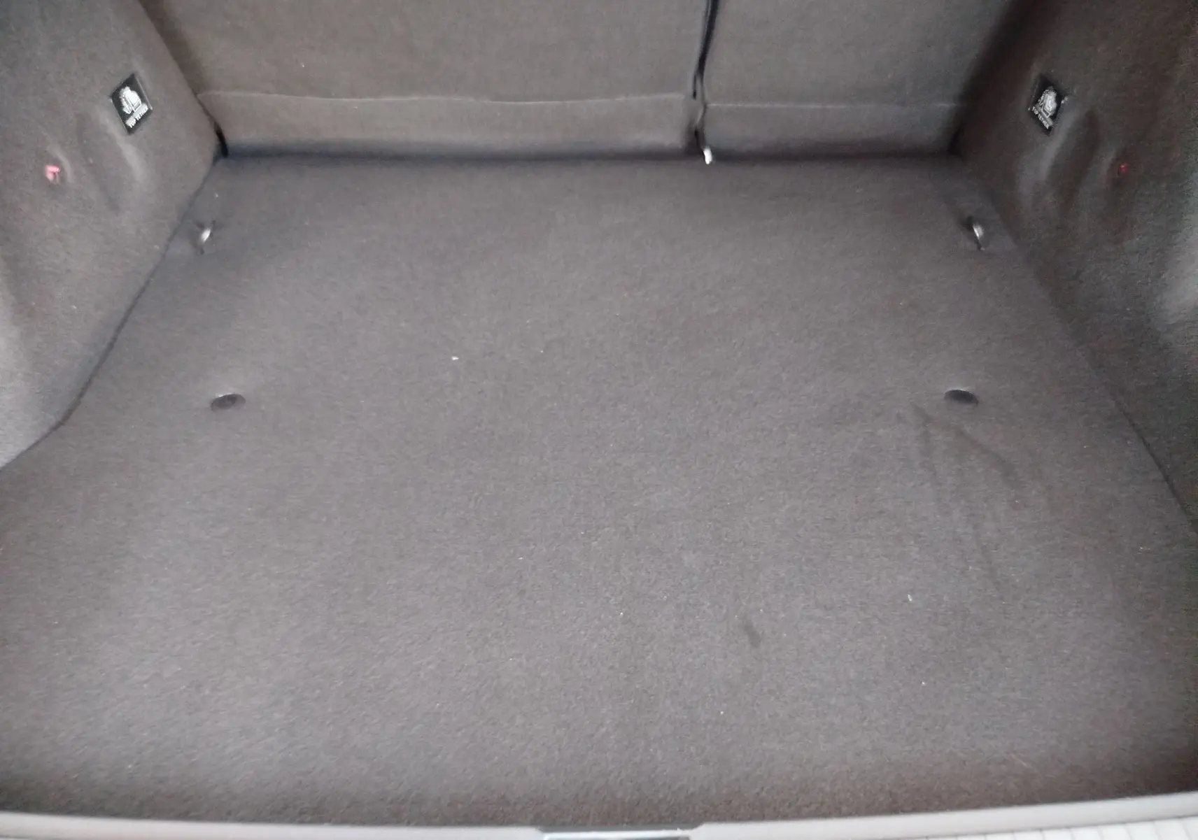 Vue plongeante sur le coffre spacieux et propre du Dacia Duster 2020, revêtement tissu gris foncé uniforme.