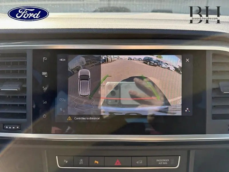 Écran tactile intérieur montrant la caméra de recul du SEAT Ateca argent, avec guidage de trajectoire en vert et rouge.