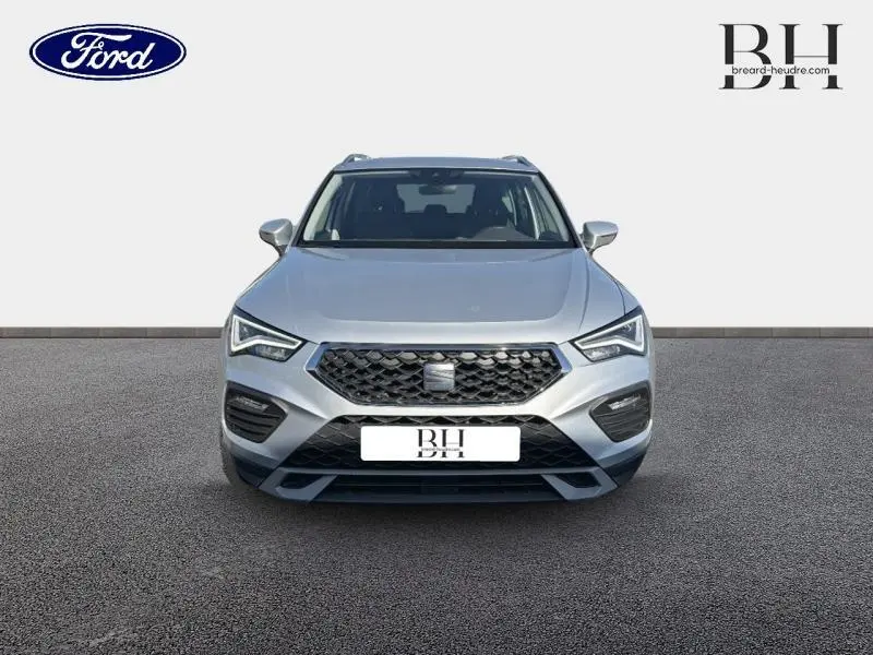 Vue avant d'un SEAT Ateca 2023 argent Reflex Métal avec calandre noire et phares LED distinctifs.