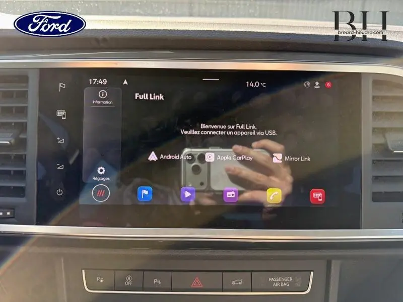 Tableau de bord avec écran tactile multimédia allumé, affichant Full Link, intérieur d'un véhicule non identifié.