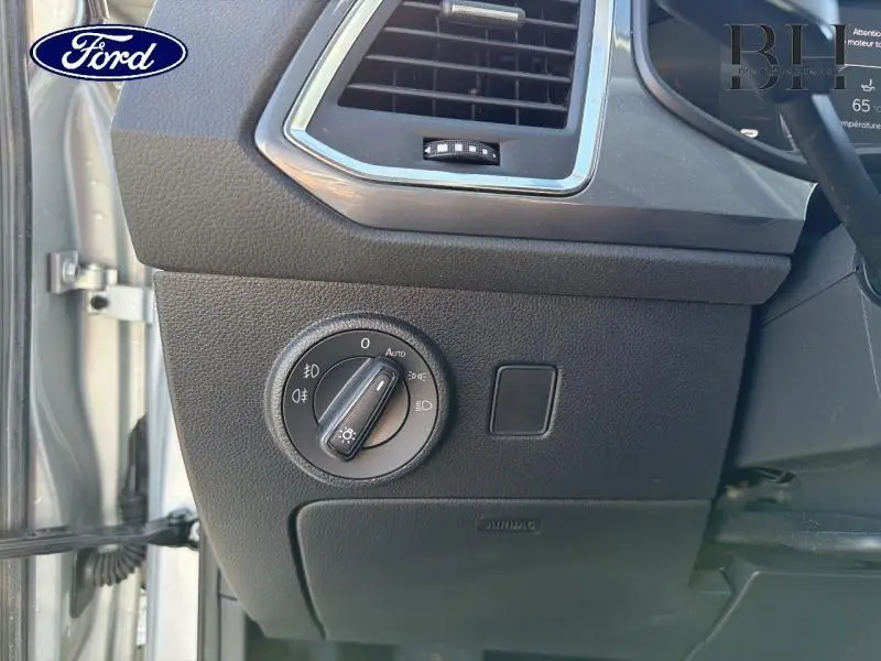 Détail du tableau de bord côté gauche avec commande des phares sur SEAT Ateca argent 2023.