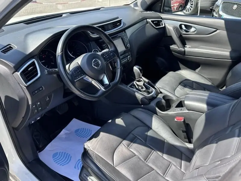 Vue intérieure côté conducteur du Nissan Qashqai 2019, montrant le volant multifonction et les sièges en cuir noir.