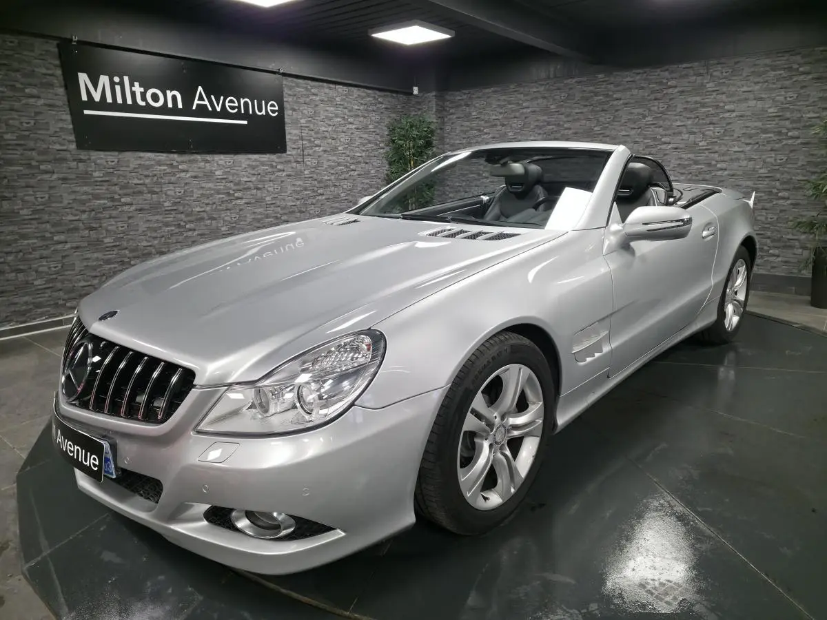 Mercedes SL 350 gris vue 3/4 avant droit, cabriolet avec jantes alliage et intérieur cuir noir visible.