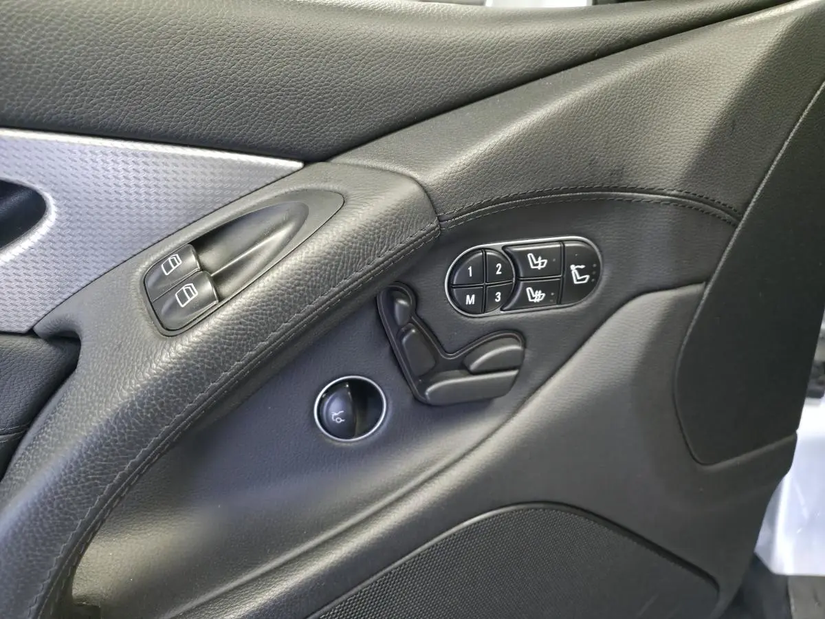 Détail de la porte intérieure côté conducteur de la Mercedes SL 350 gris, avec commandes de sièges et boutons de vitres.