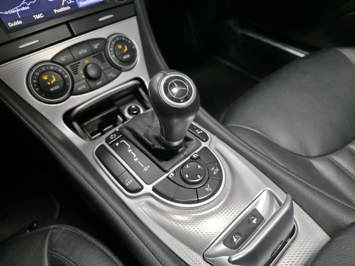 Gros plan sur la console centrale et levier de vitesses cuir noir d’une Mercedes SL 350 gris, intérieur cuir noir.