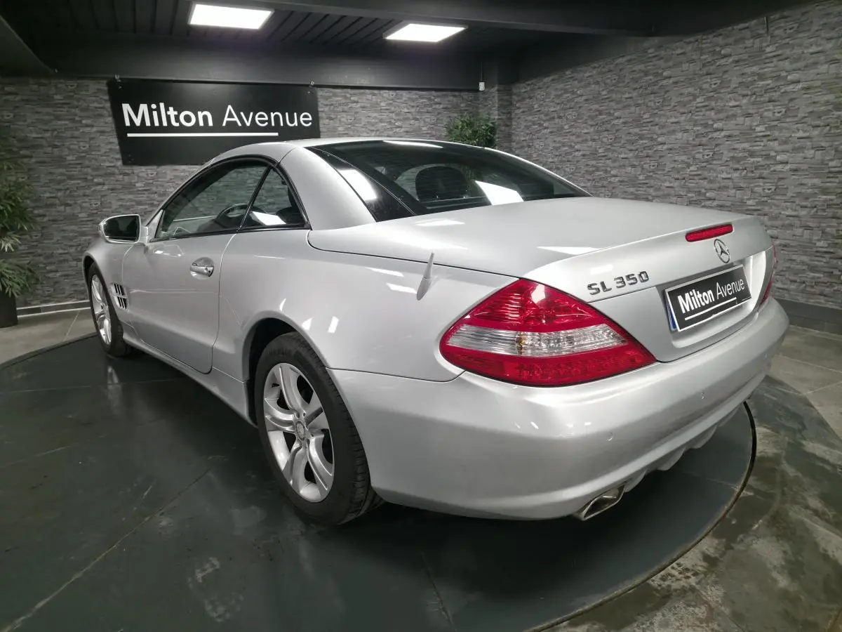 Vue 3/4 arrière droite d'une Mercedes SL 350 gris métallisé avec jantes alliage et toit rigide fermé.